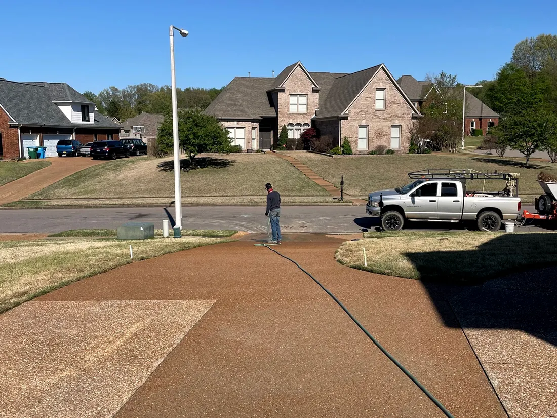 Exposed aggregate driveway curving up to a house on a clear day
