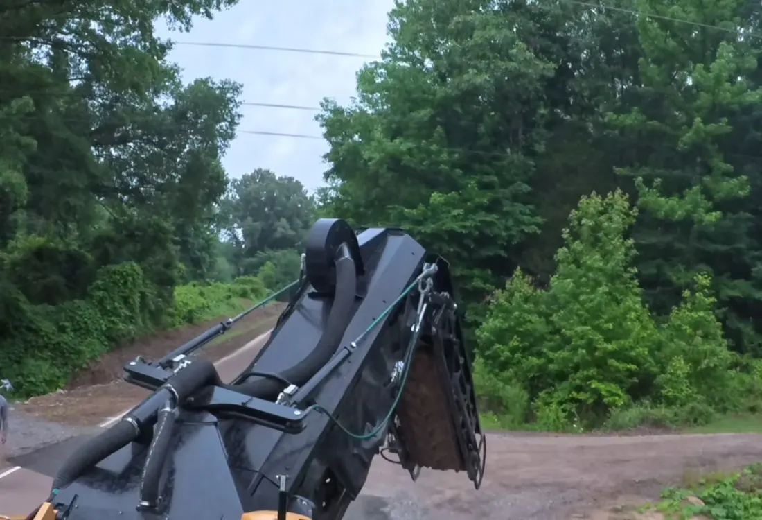 Milling attachment positioned over a road surface