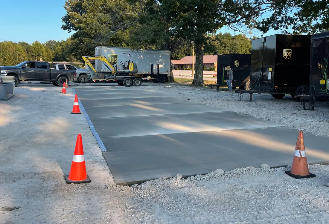 Concrete lot pour in progress with cones and equipment