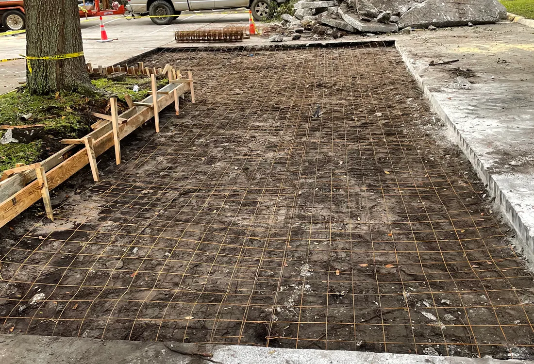 Slab removal in progress with exposed base and a truck on site